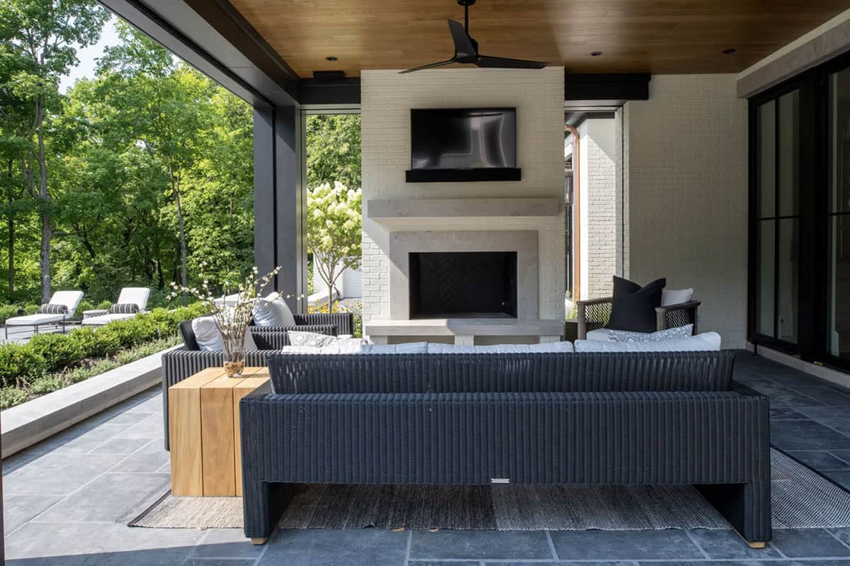 Outdoor living room with fireplace and wicker sectional seating