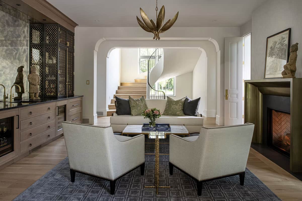 Lounge area framed by bar cabinetry and curved staircase