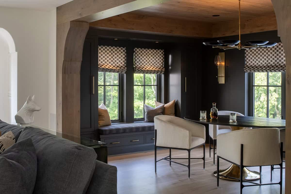 Moody window seat nook with checkered roman shades and dark cabinetry