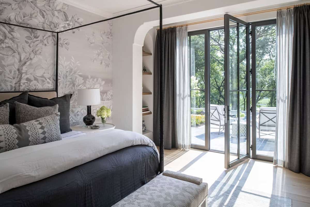 Canopy bed framed by mural wallpaper and arched balcony doors