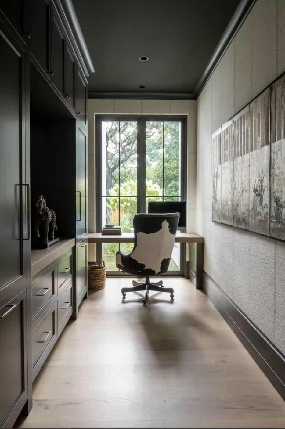 Dark home office nook with cowhide chair and grasscloth walls