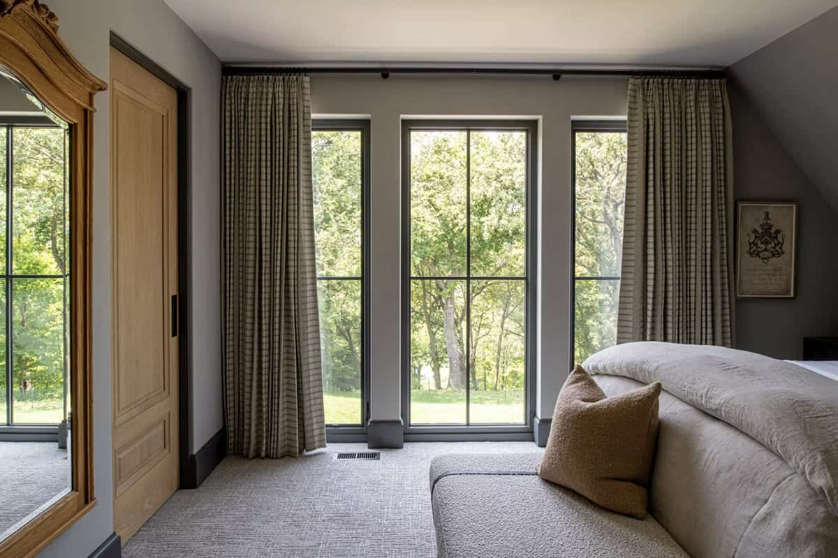 Bedroom nook with plaid curtains framing a wooded view