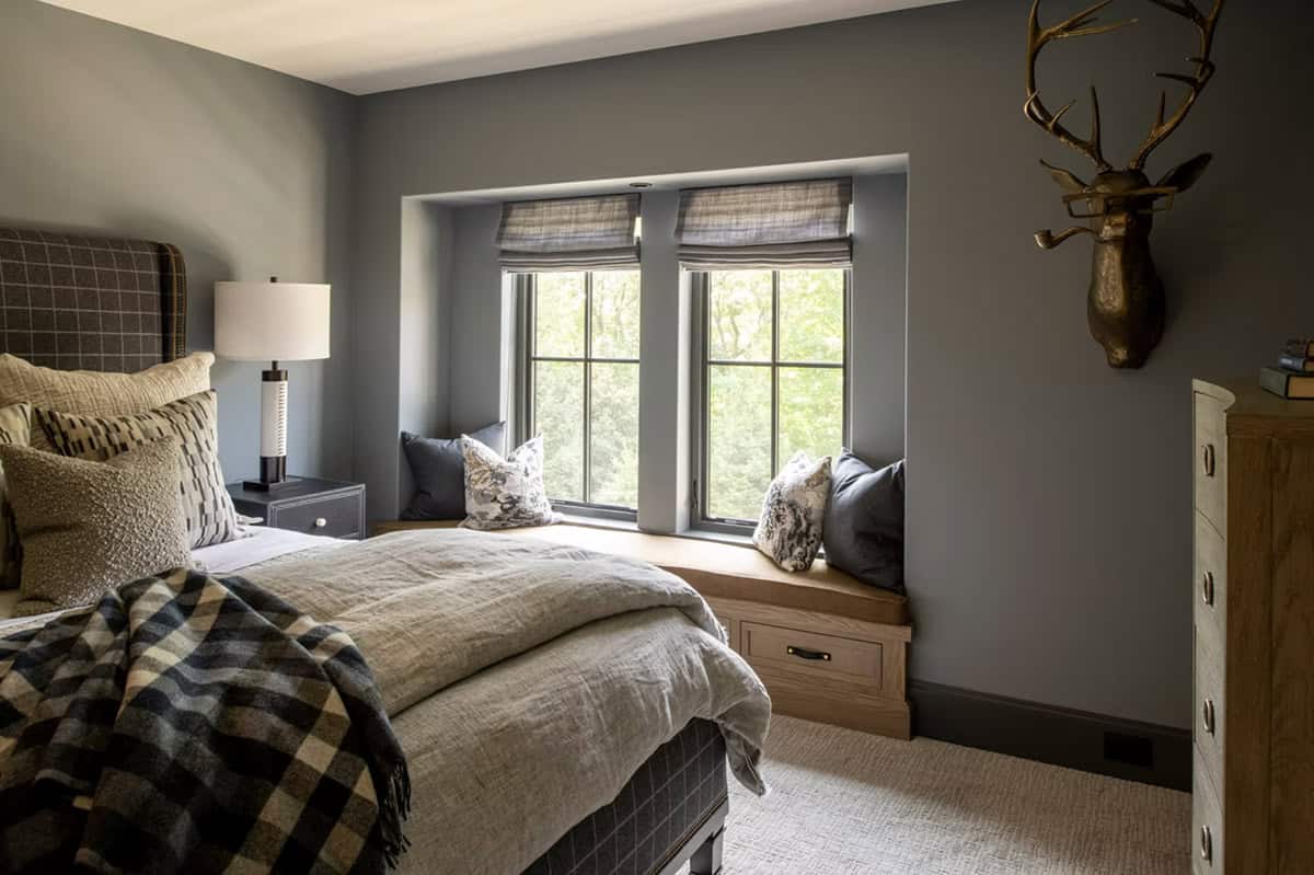 Guest bedroom with mounted deer head and window seat nook