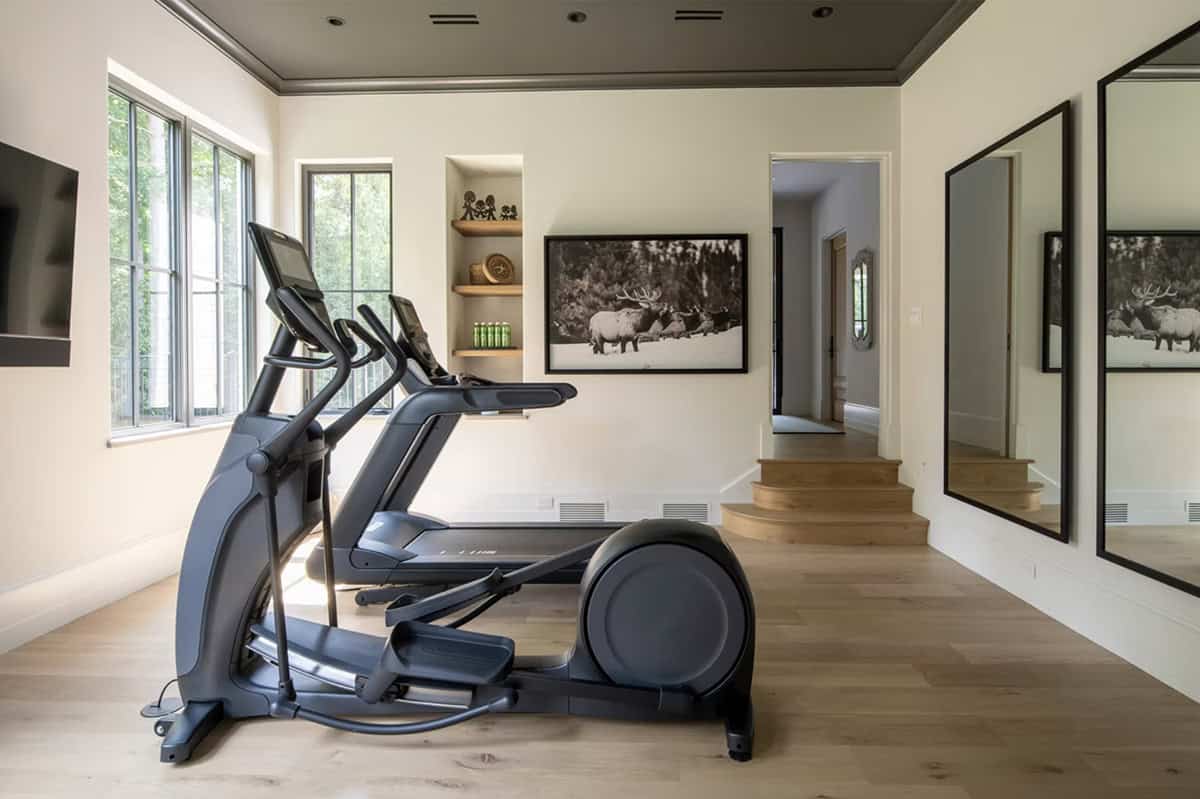 Home gym with elliptical machine and mirrored wall panels