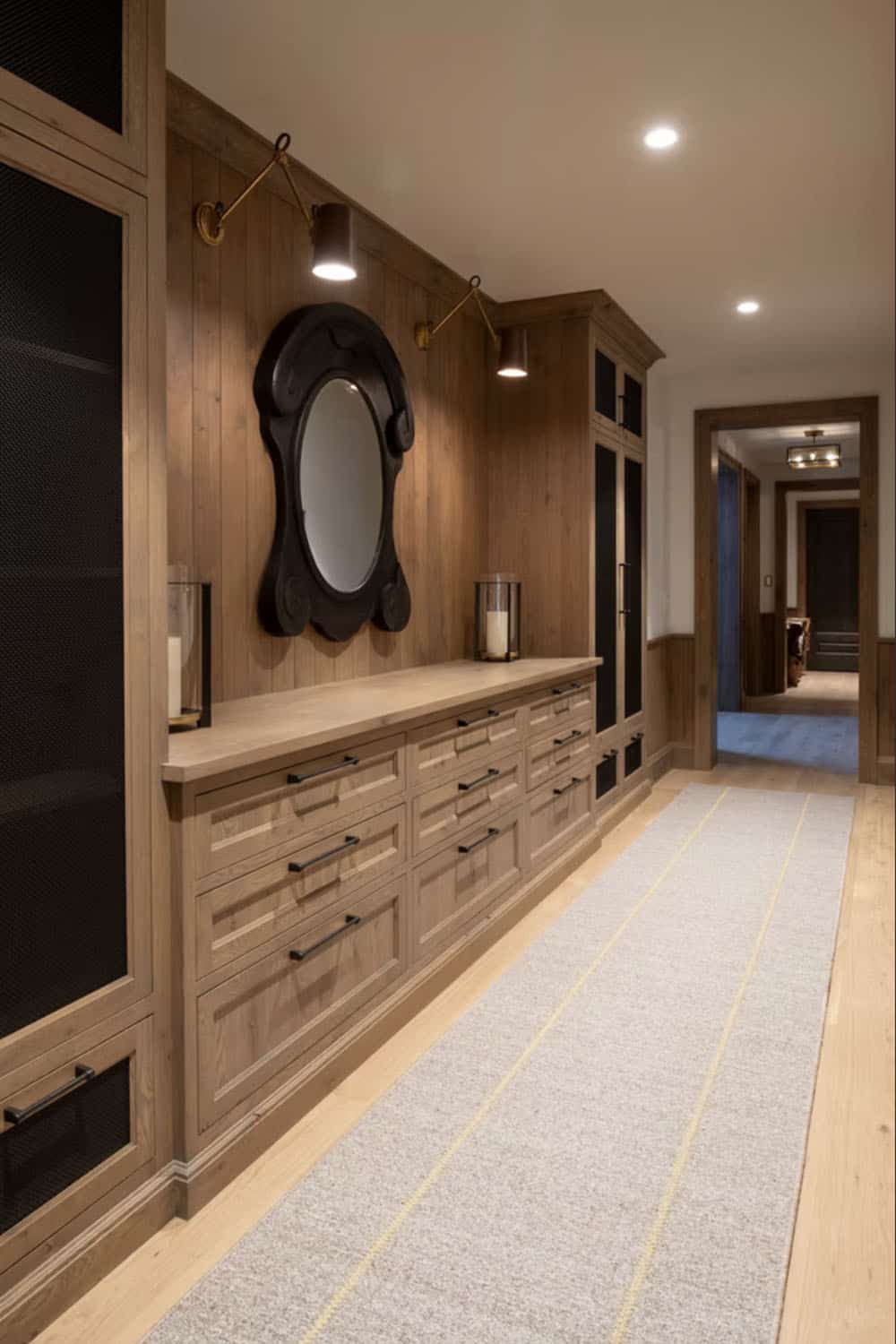 Wood paneled hallway with oval mirror and built-in dresser