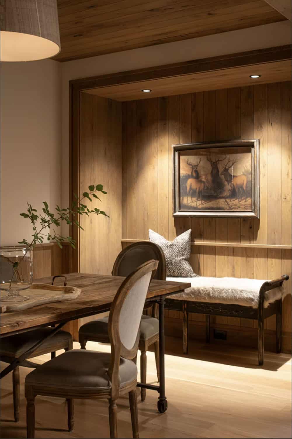 Wood paneled dining nook with vintage stag print and daybed