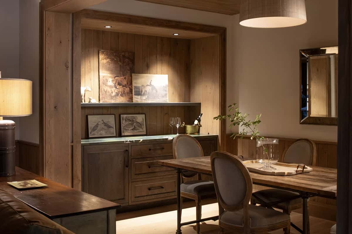 Wood paneled bar nook with vintage equestrian prints and stemware