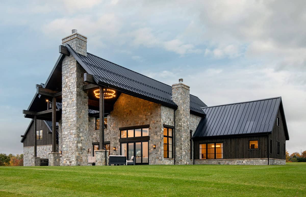 Side exterior view with stone chimney and covered wood terrace