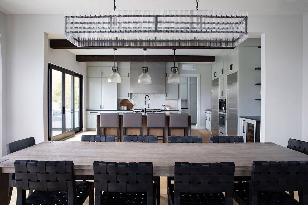 Dining room with woven leather chairs and open kitchen view