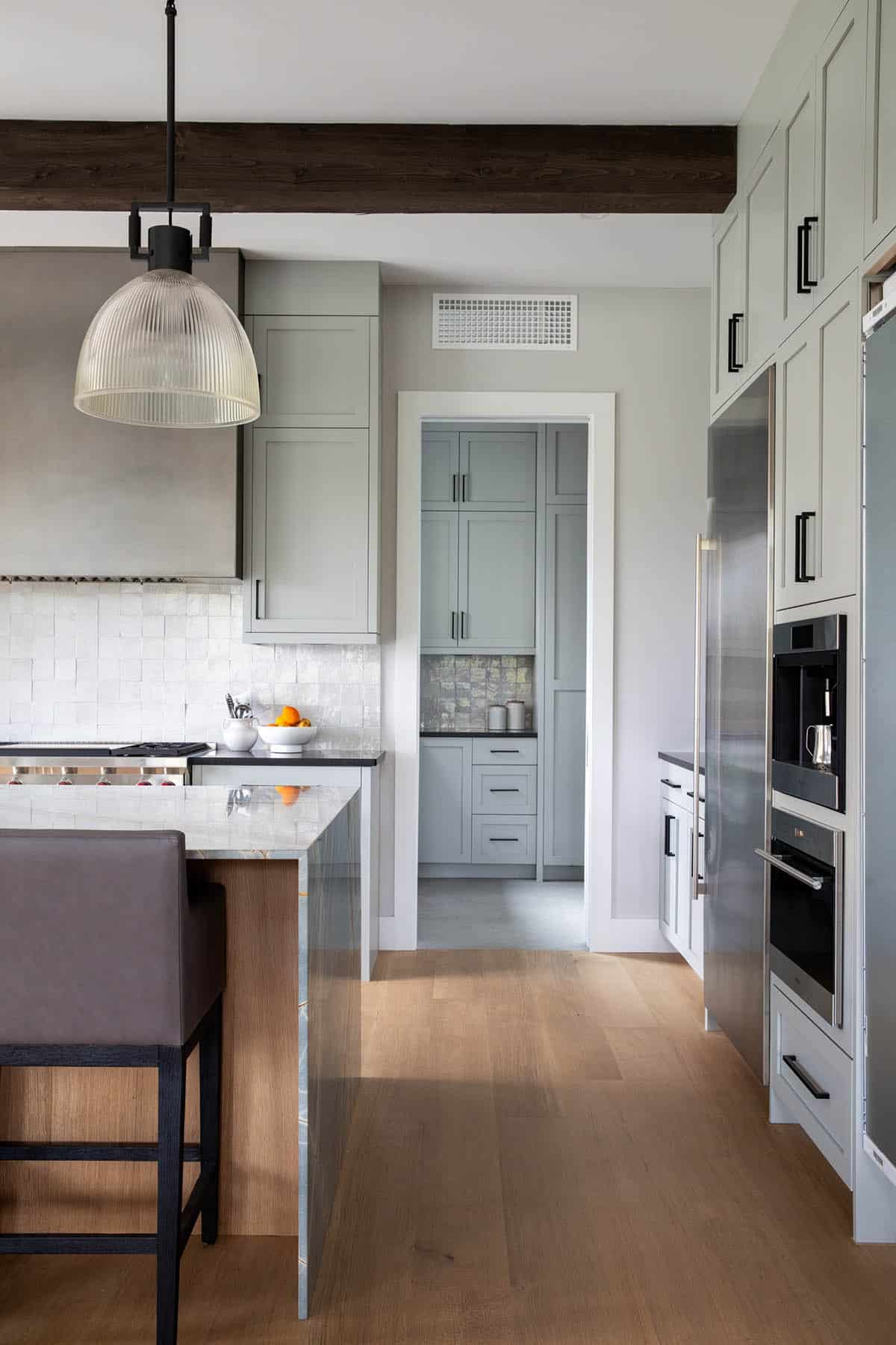 Kitchen hallway view toward pantry and built-in stainless appliances