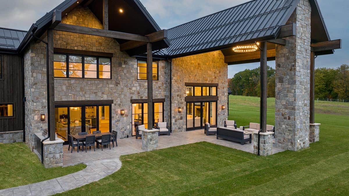 Rear patio with dining table and stone covered porch