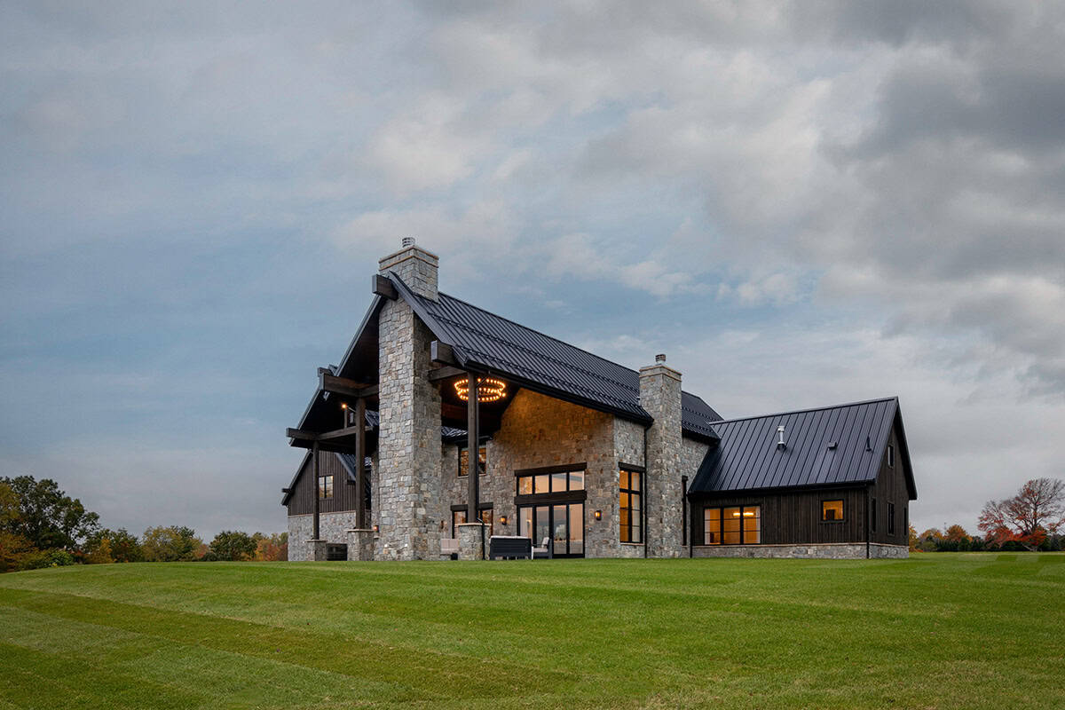 Rear exterior at dusk with covered patio and stone columns