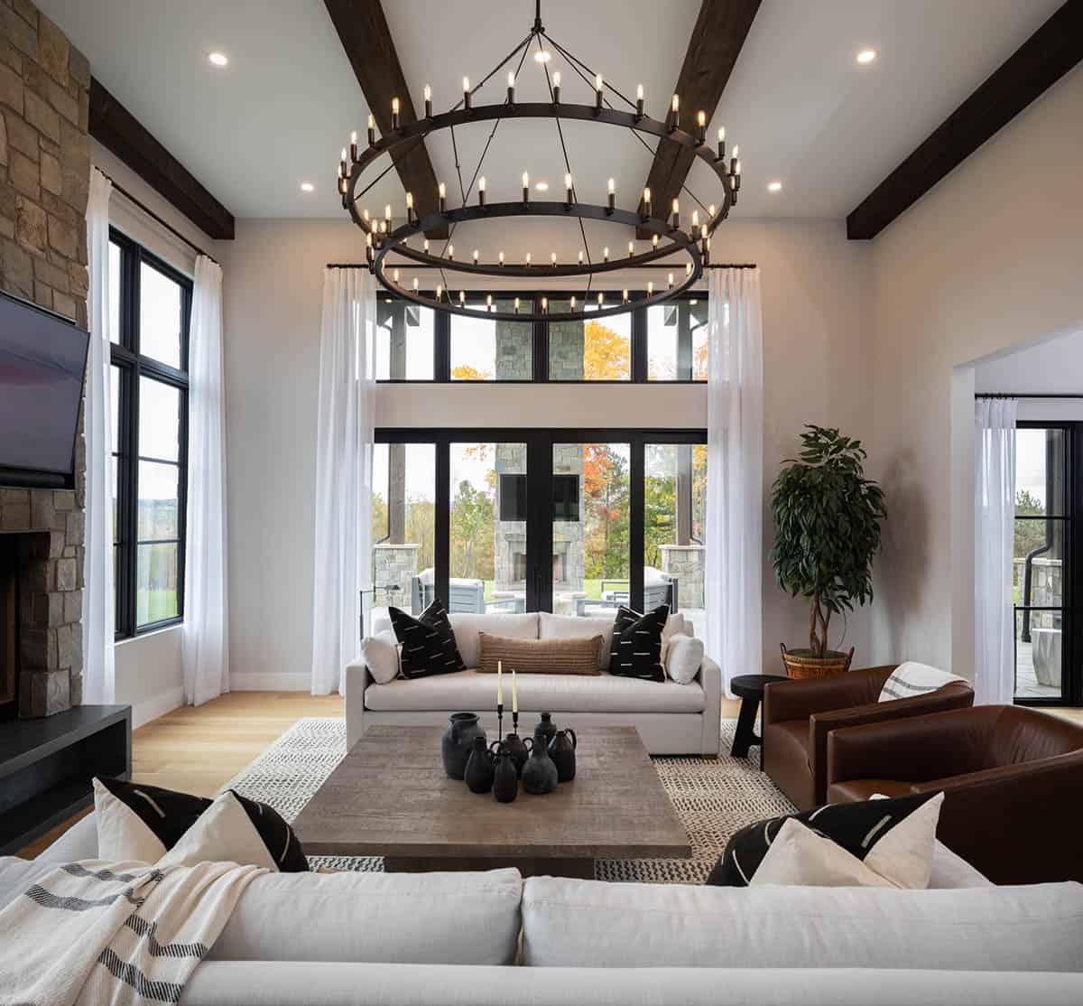 Living room seating area facing tall windows and outdoor patio