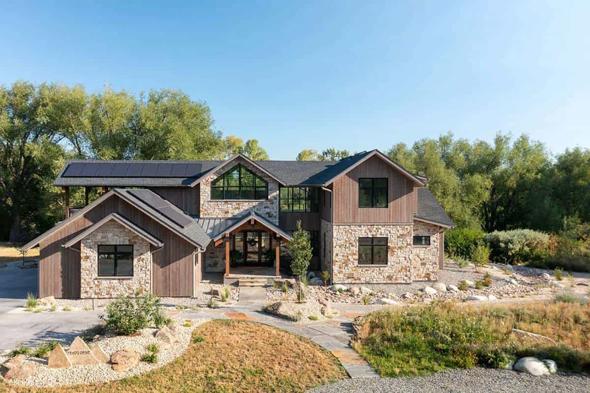 Front exterior with gabled stone entry, timber porch, and black-framed windows