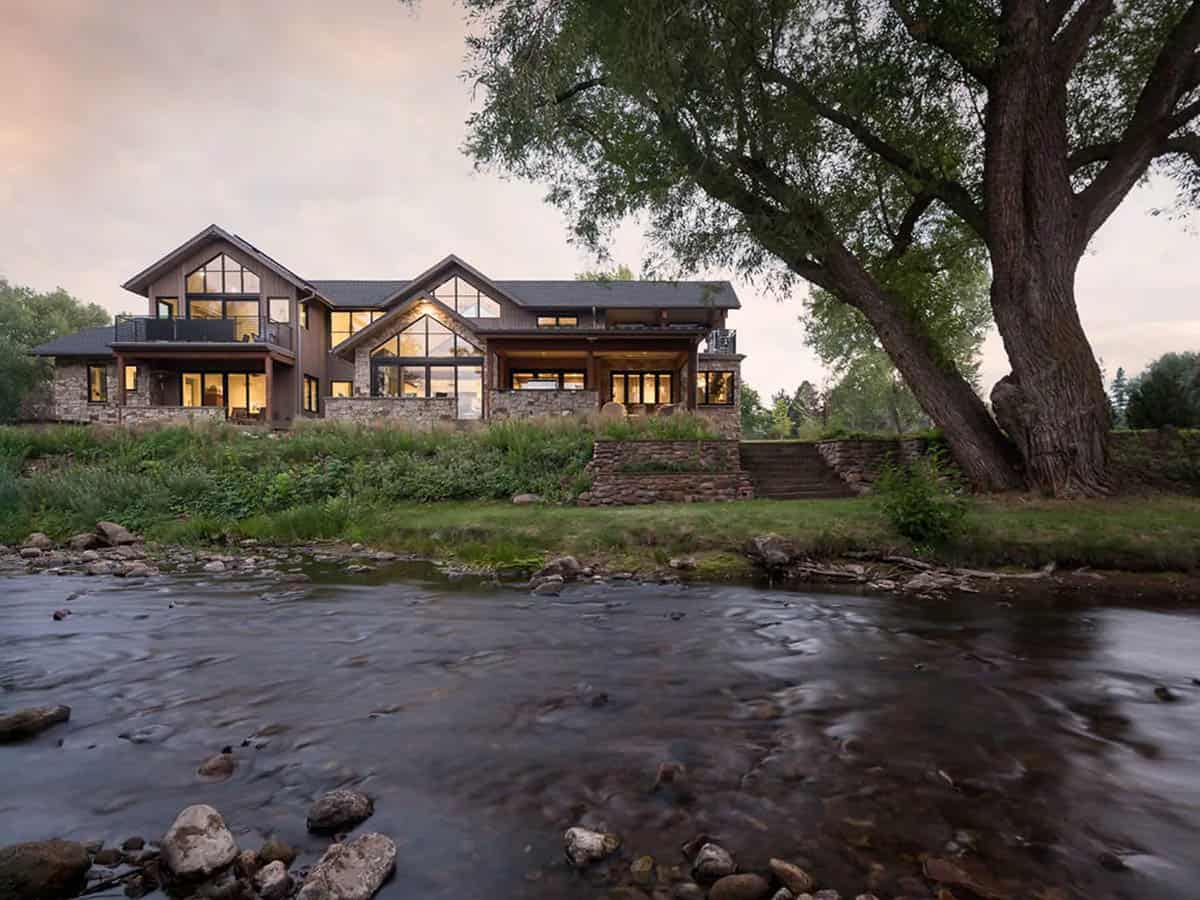Creekside rear elevation with tall glass gables and a large tree
