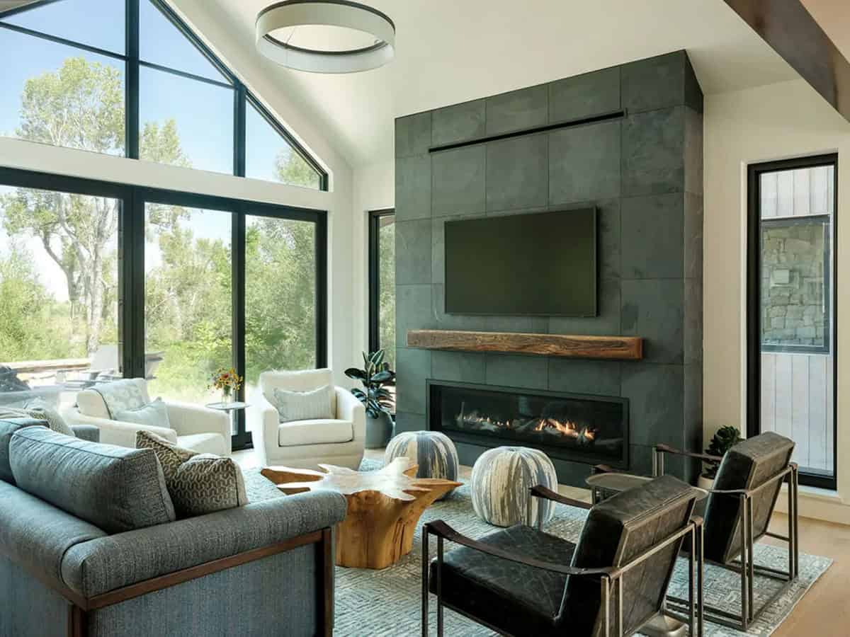 Slate fireplace wall and floor-to-ceiling windows in vaulted living room