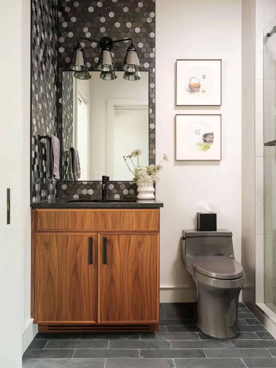 Bathroom with walnut vanity, hexagon tile mirror surround, and slate floor 