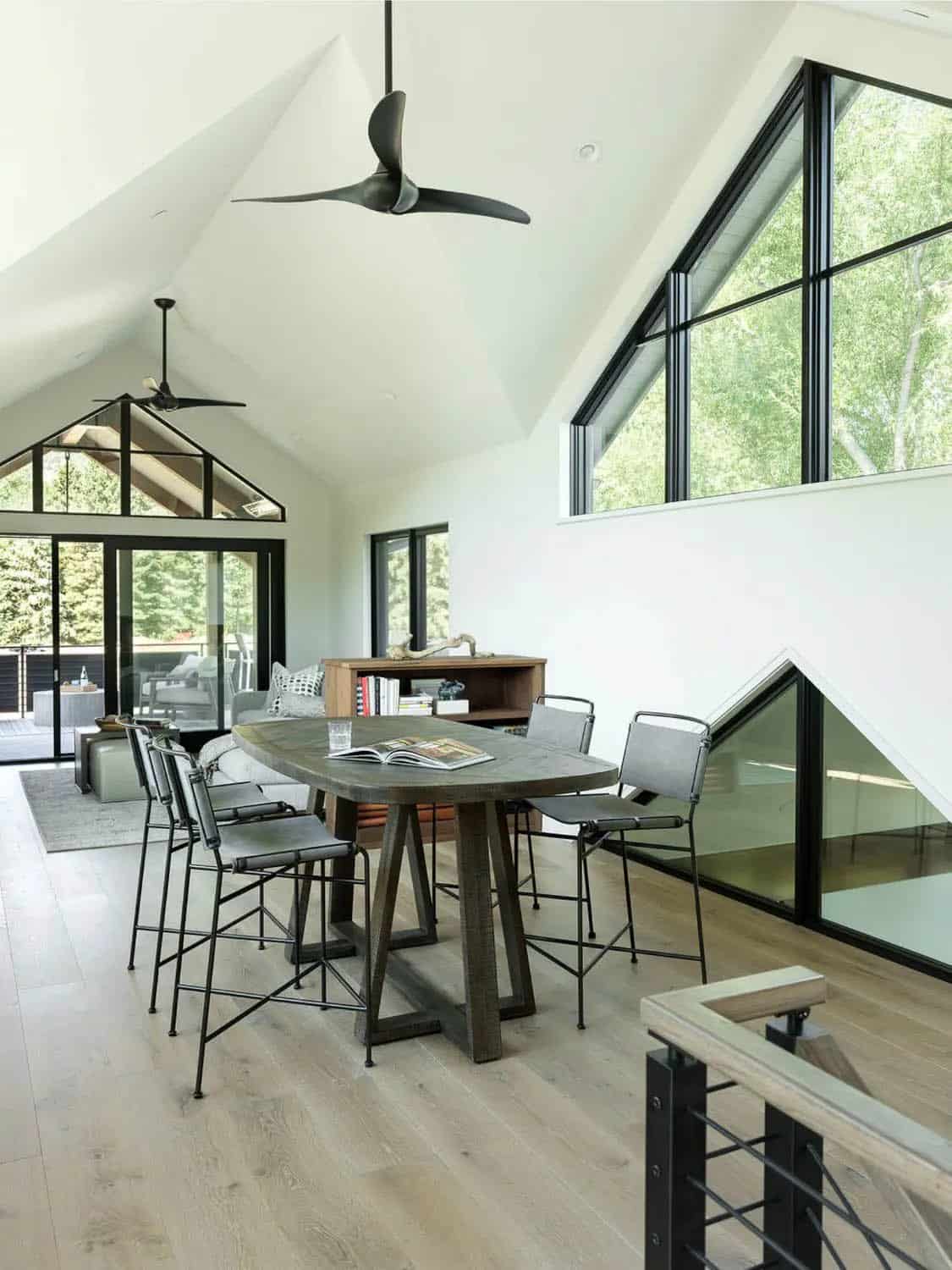 Upstairs loft with vaulted ceiling, angled windows, and counter-height table