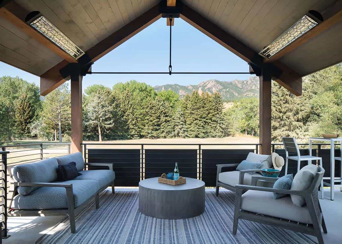 Covered deck with timber beams, overhead heaters, lounge seating, and mountain views 