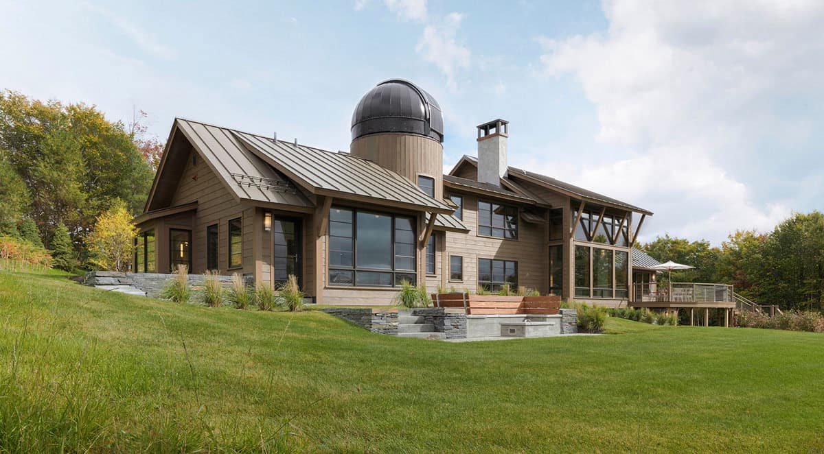 Modern mountain home exterior with observatory dome and standing seam metal roof