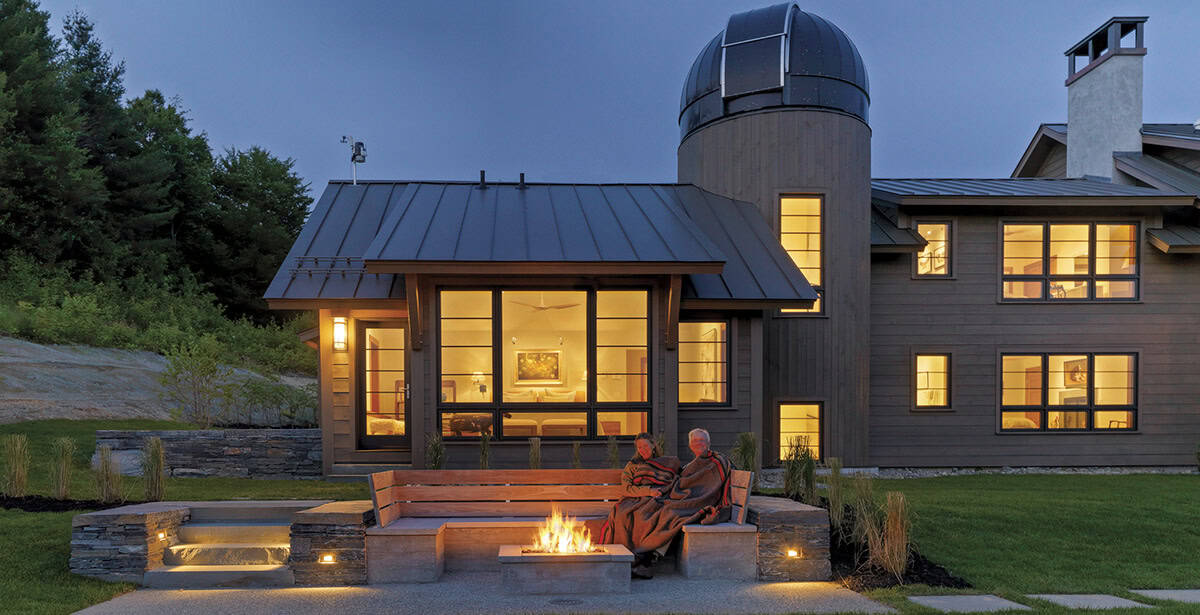 Evening view of mountain home with fire pit and glowing observatory tower