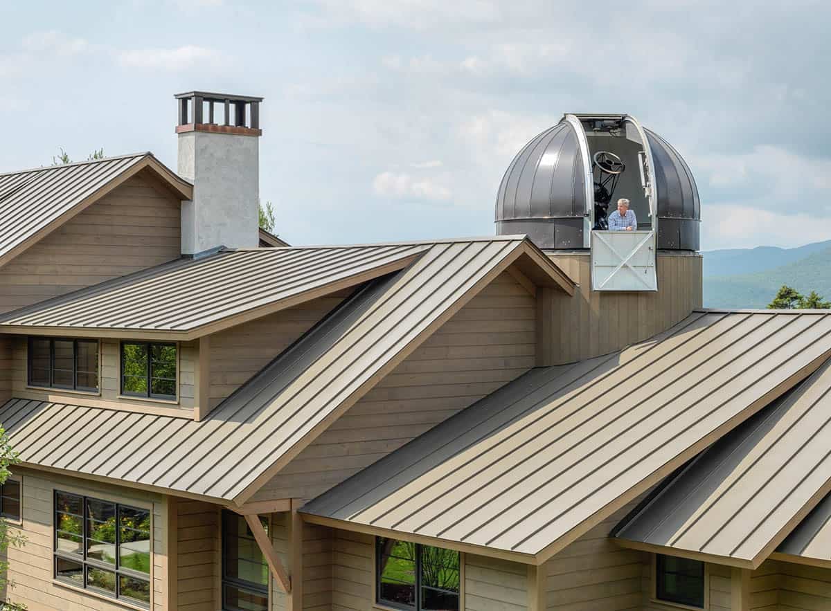 Rooftop observatory dome open with telescope and mountain views beyond