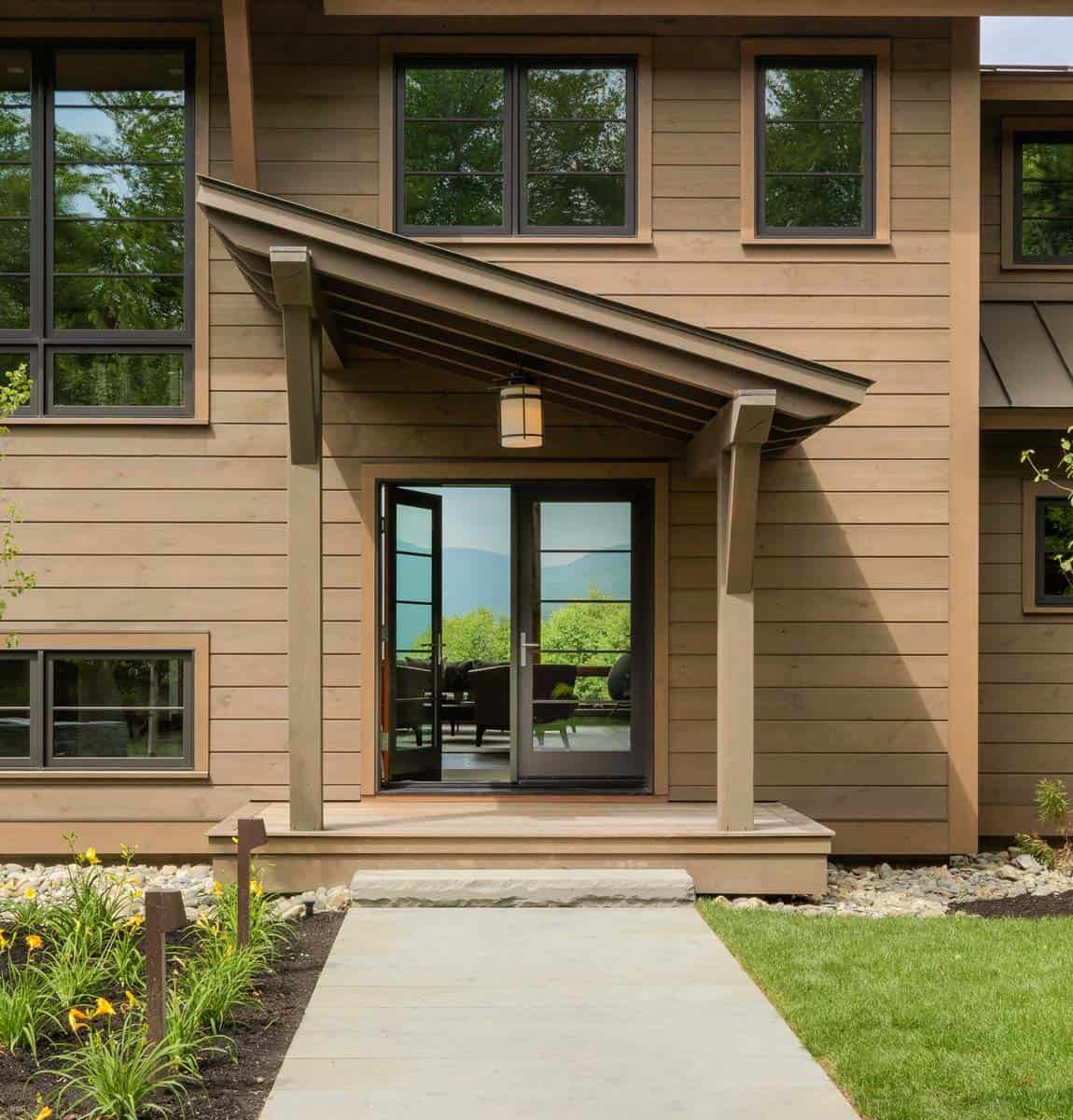 Covered entry with cantilevered awning roof and mountain view through doors