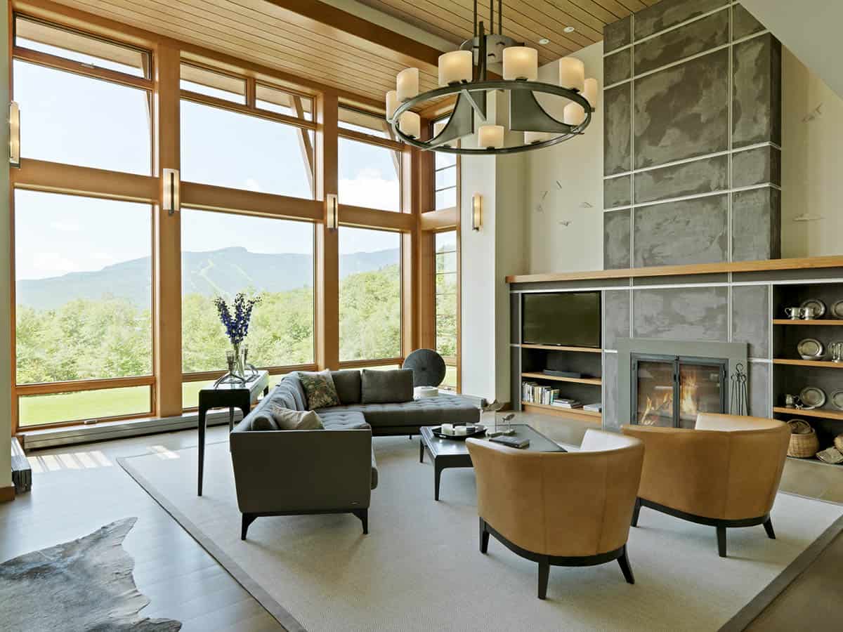 Great room with vaulted wood ceiling, stone fireplace, and mountain windows