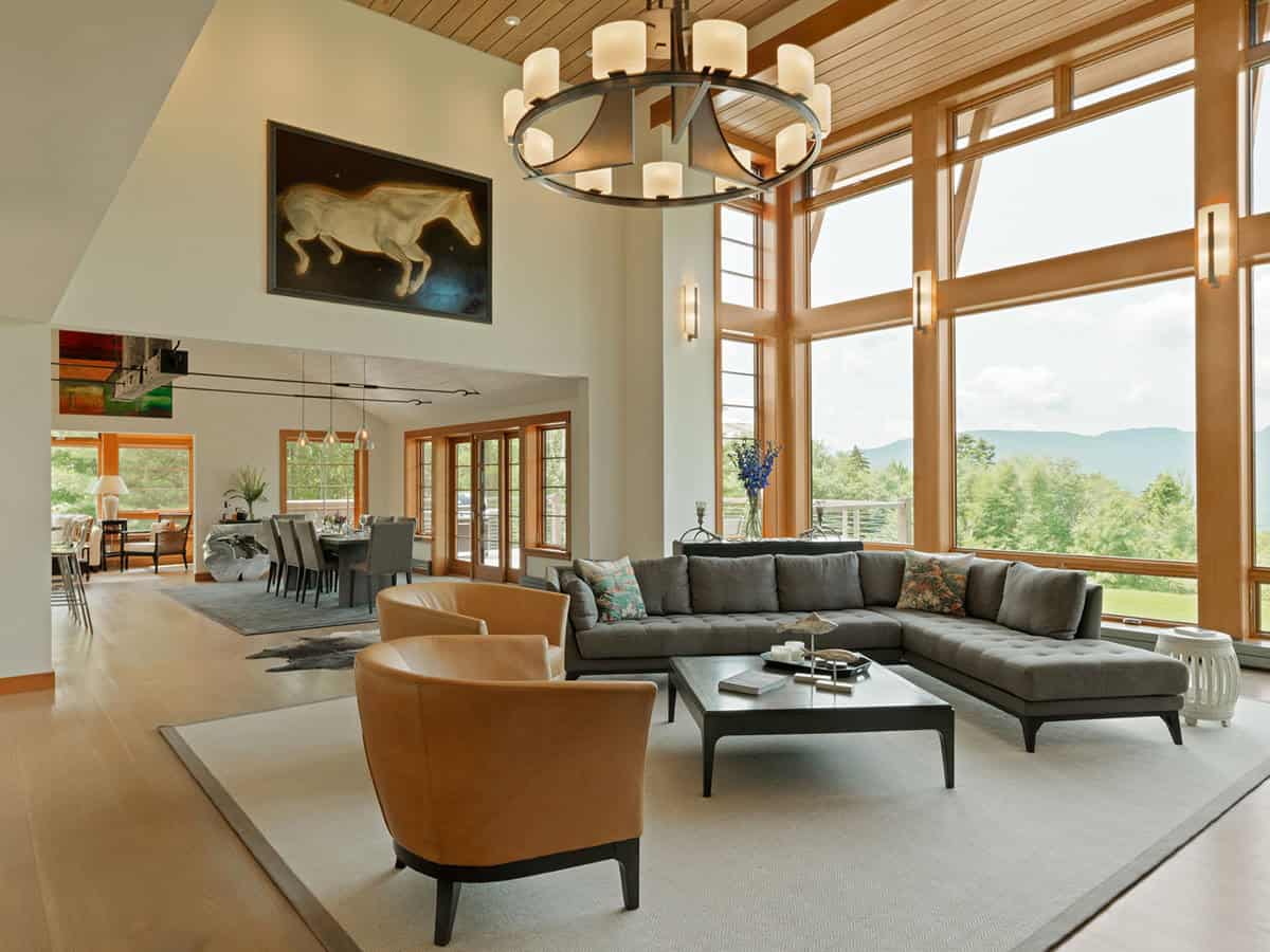 Sectional sofa facing floor to ceiling windows with layered mountain views