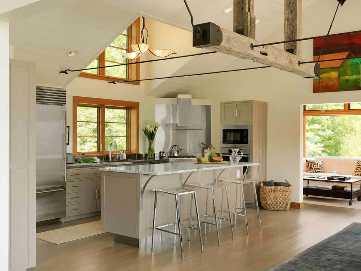 Kitchen island with reclaimed beam pendant lighting and stainless appliances