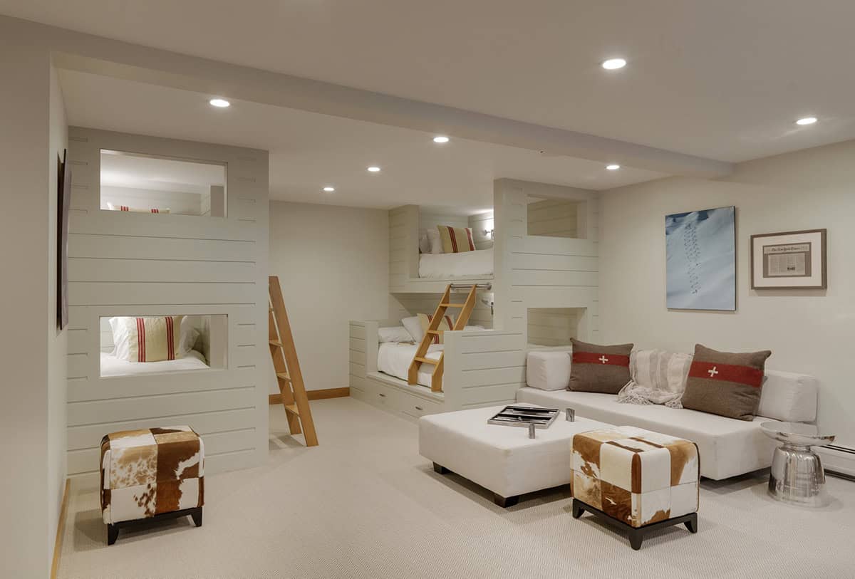 Bunk room with built in beds, cowhide ottomans, and ski decor