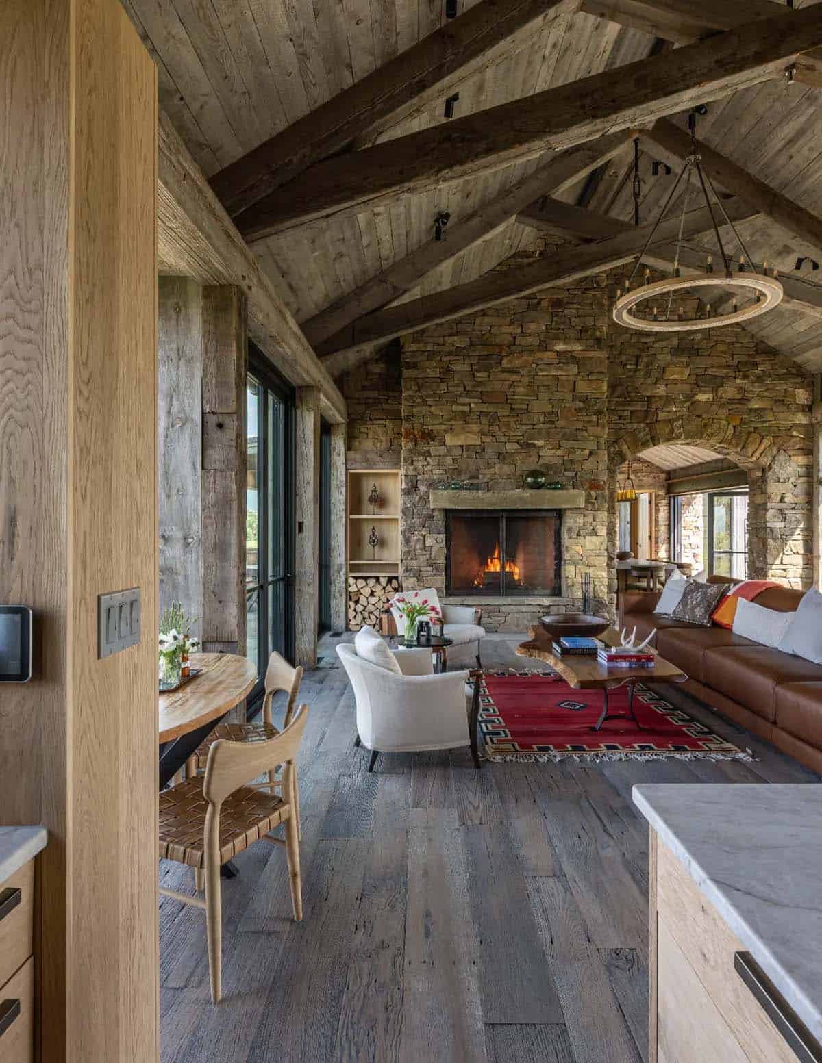 Living room with stone fireplace, exposed beams and wide plank floors