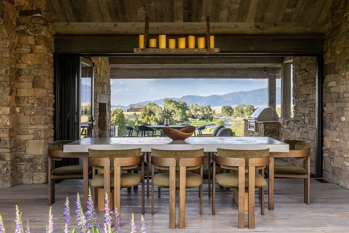 Outdoor dining table with olive green chairs and mountain backdrop