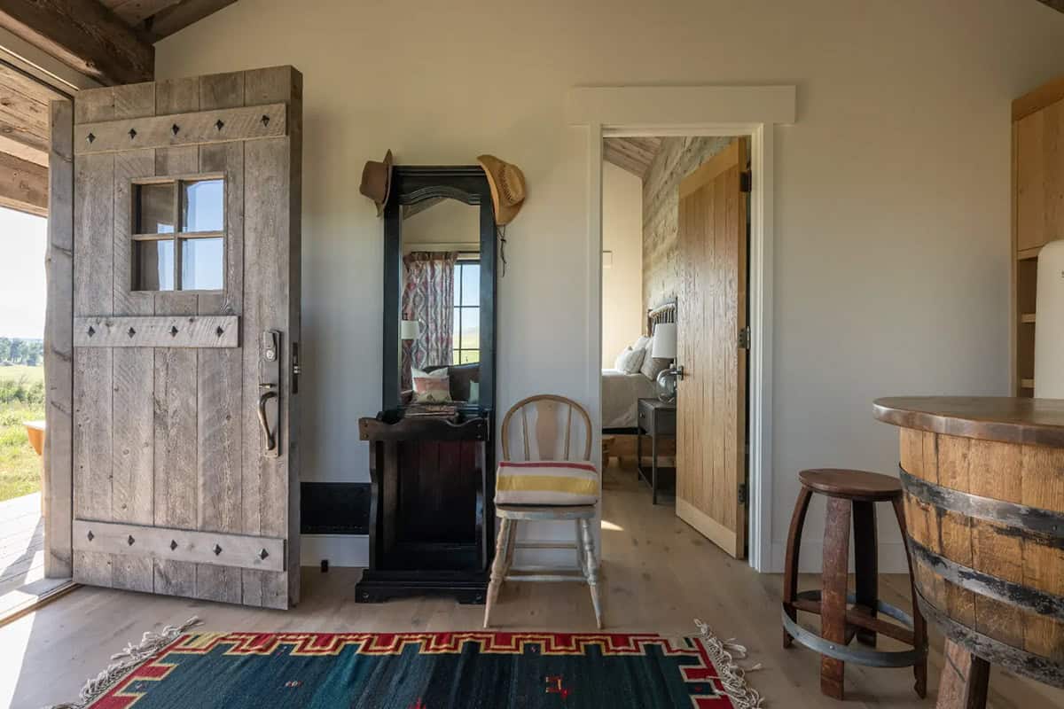 Cabin entry with rustic plank door and whiskey barrel bar