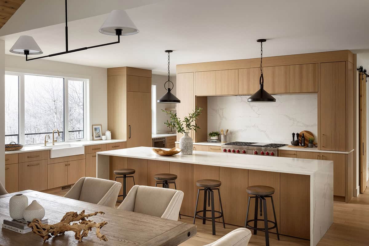 Open kitchen with white oak cabinetry and marble waterfall island