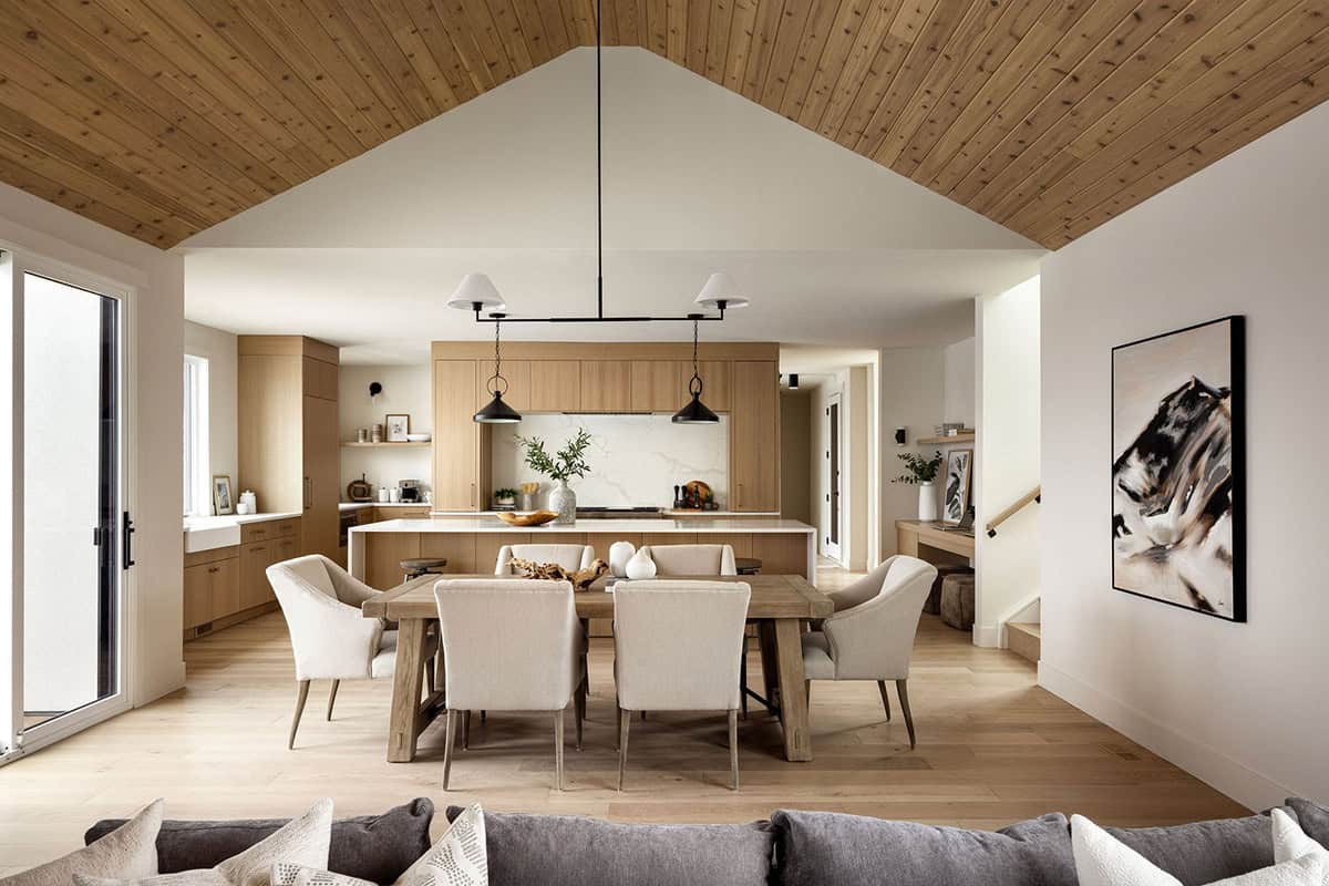 Dining area with vaulted wood ceiling and mountain landscape art