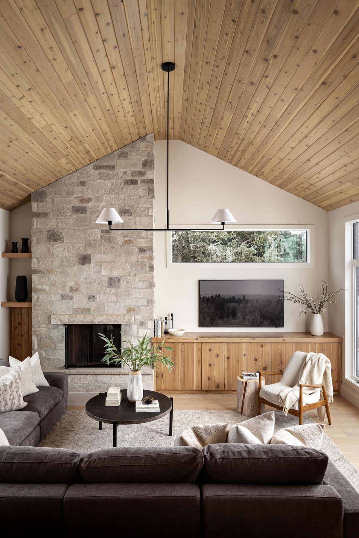 Living room with vaulted wood ceiling and stone fireplace wall