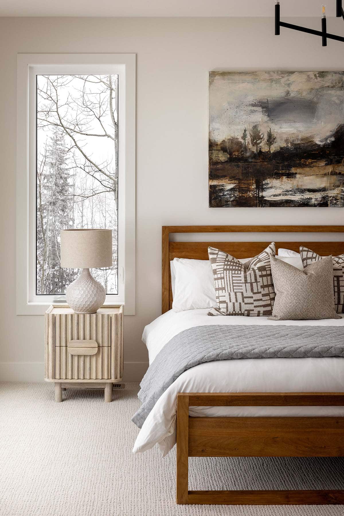 Bedroom nightstand with ribbed wood finish beside upholstered bed frame