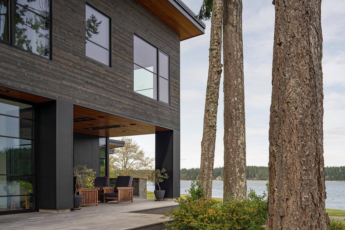 Corner of the home viewed through tall pine tree trunks