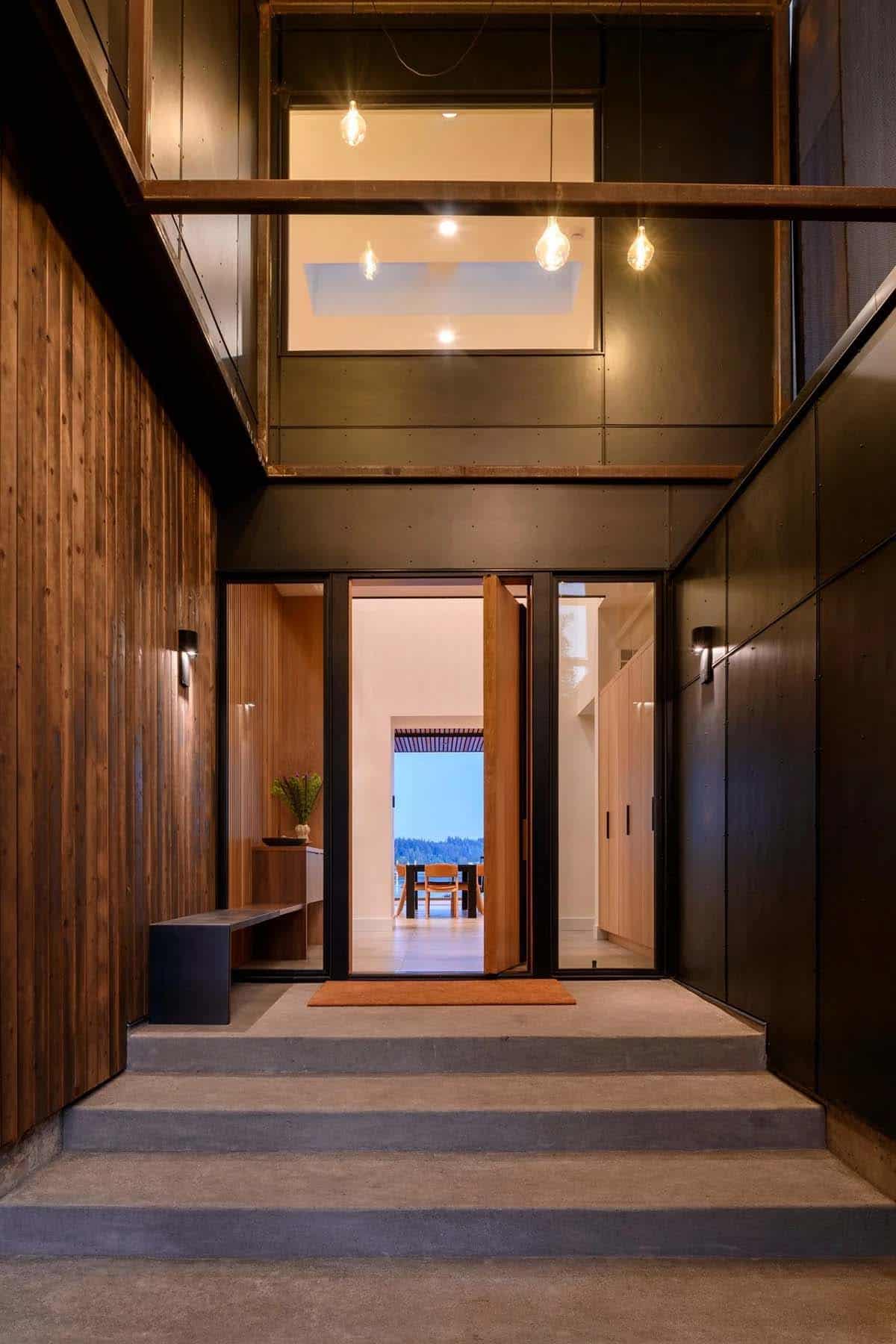 Woman walks through open pivot door into dusk entry hall