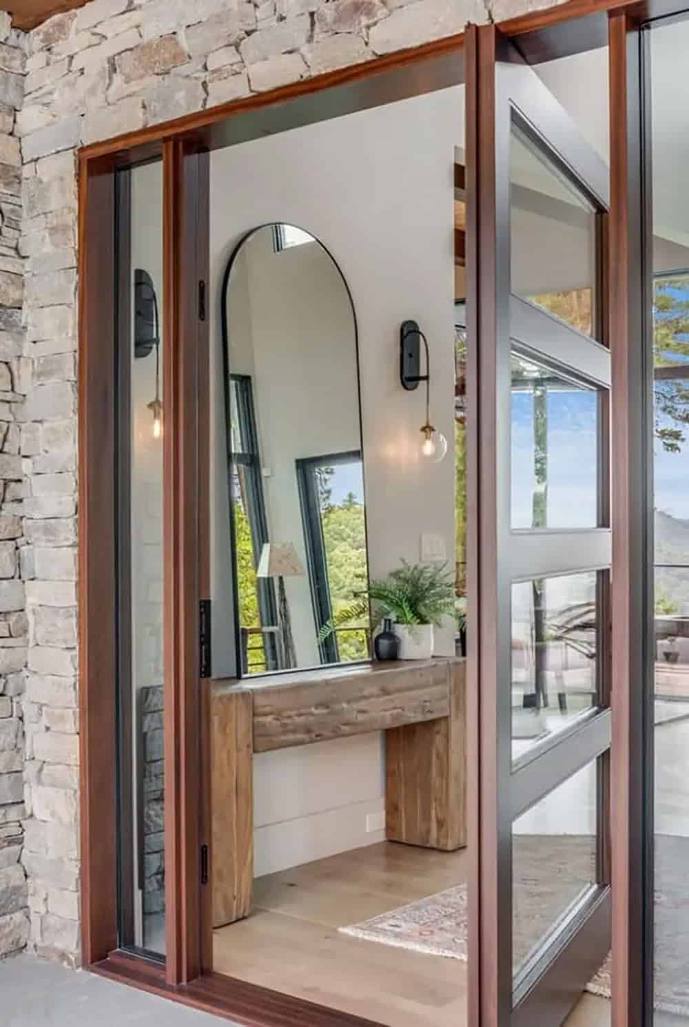 Open pivot door revealing entryway console and arched mirror