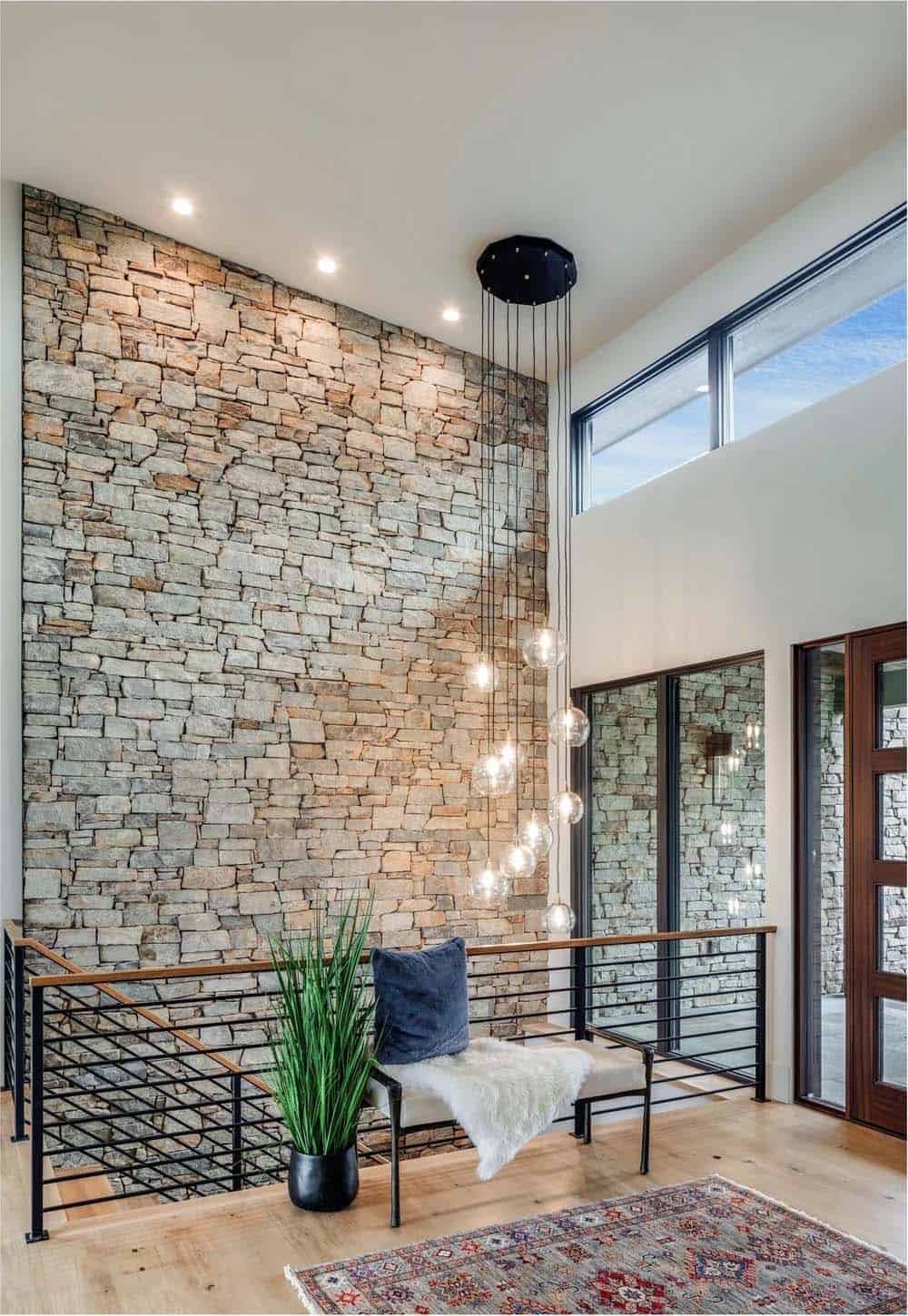 Two story stone accent wall with cascading globe pendant lighting