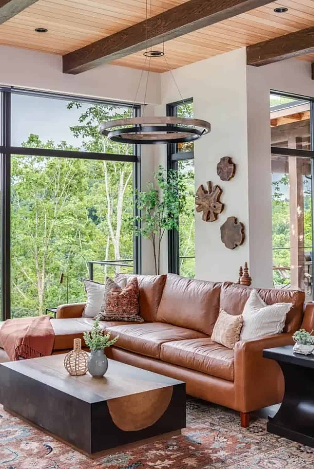 Leather sofa corner with wood slice wall art and floor to ceiling windows