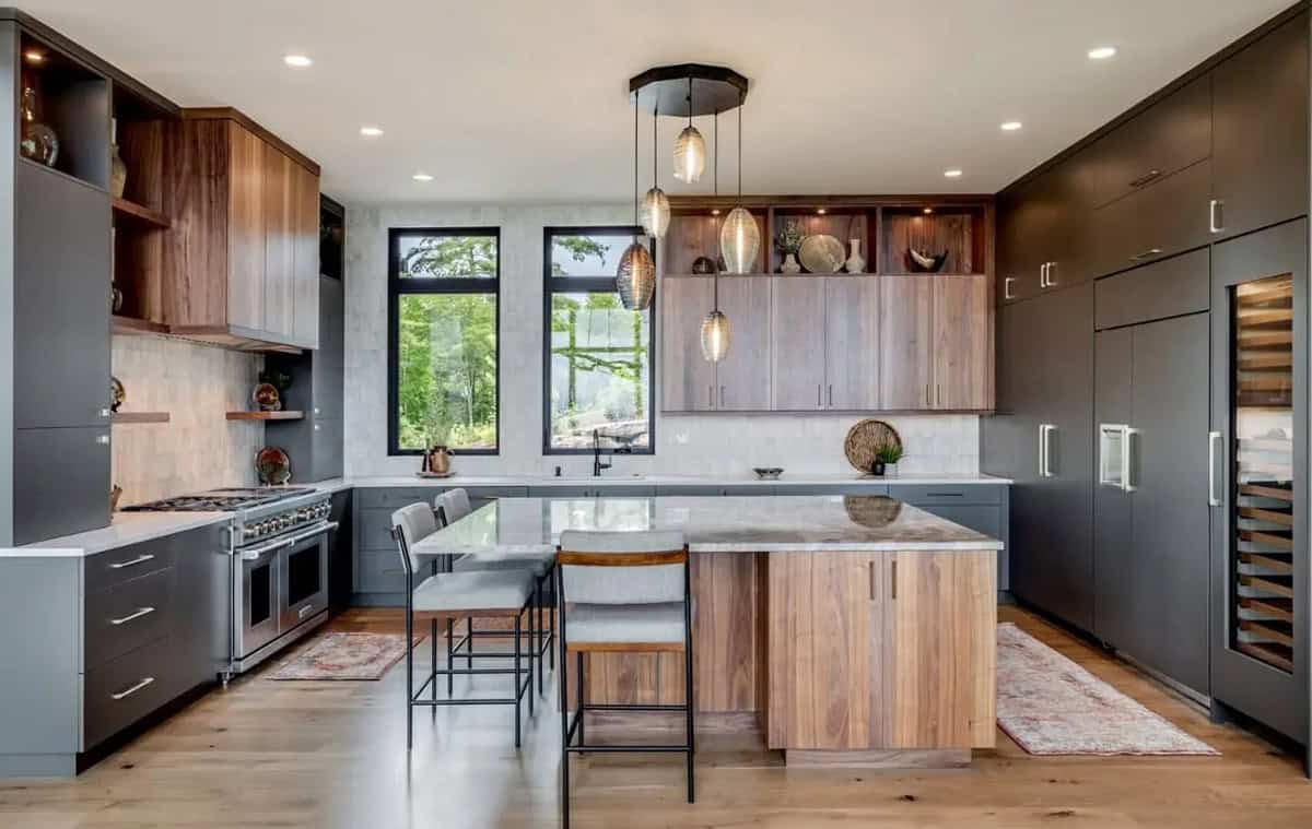 Kitchen with charcoal cabinetry, walnut island, and glass pendant lighting
