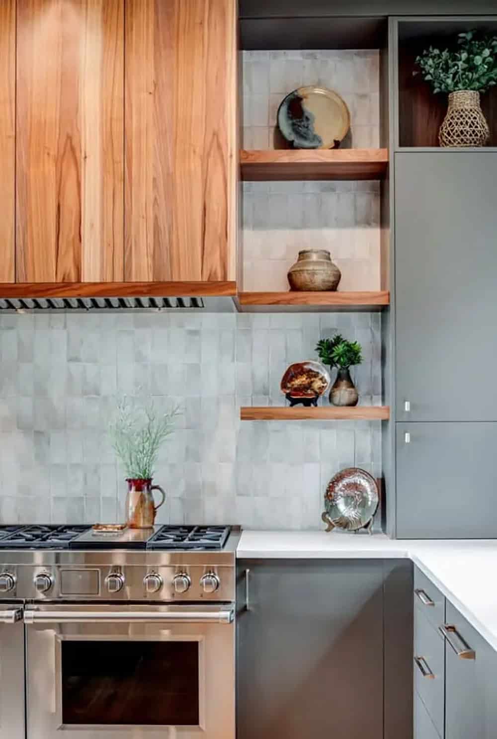 Close up of kitchen open shelving with pottery and tile backsplash