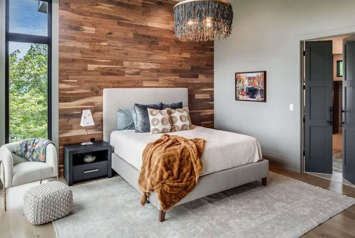 Bedroom with reclaimed wood accent wall and beaded chandelier