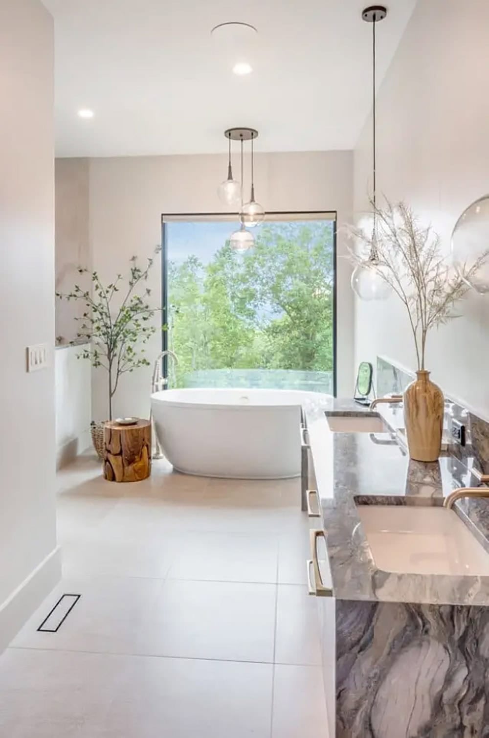 Primary bathroom with freestanding tub and dual marble vanity
