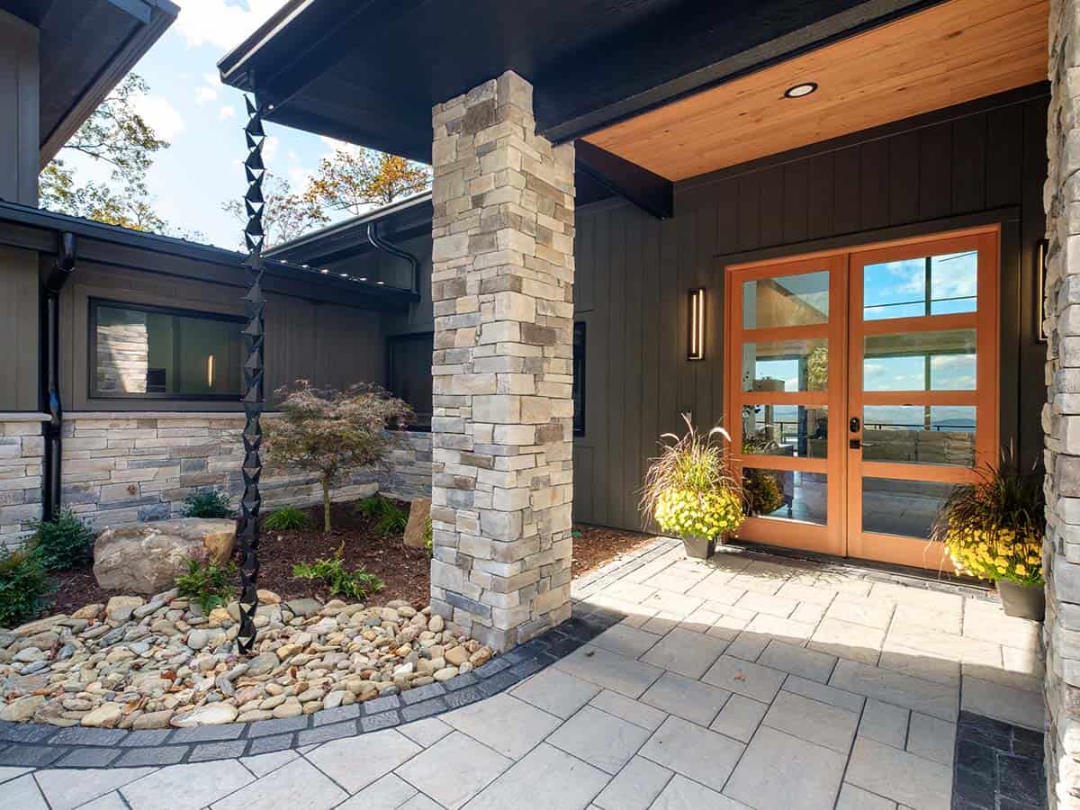 Covered entry walkway with stone column and river rock bed