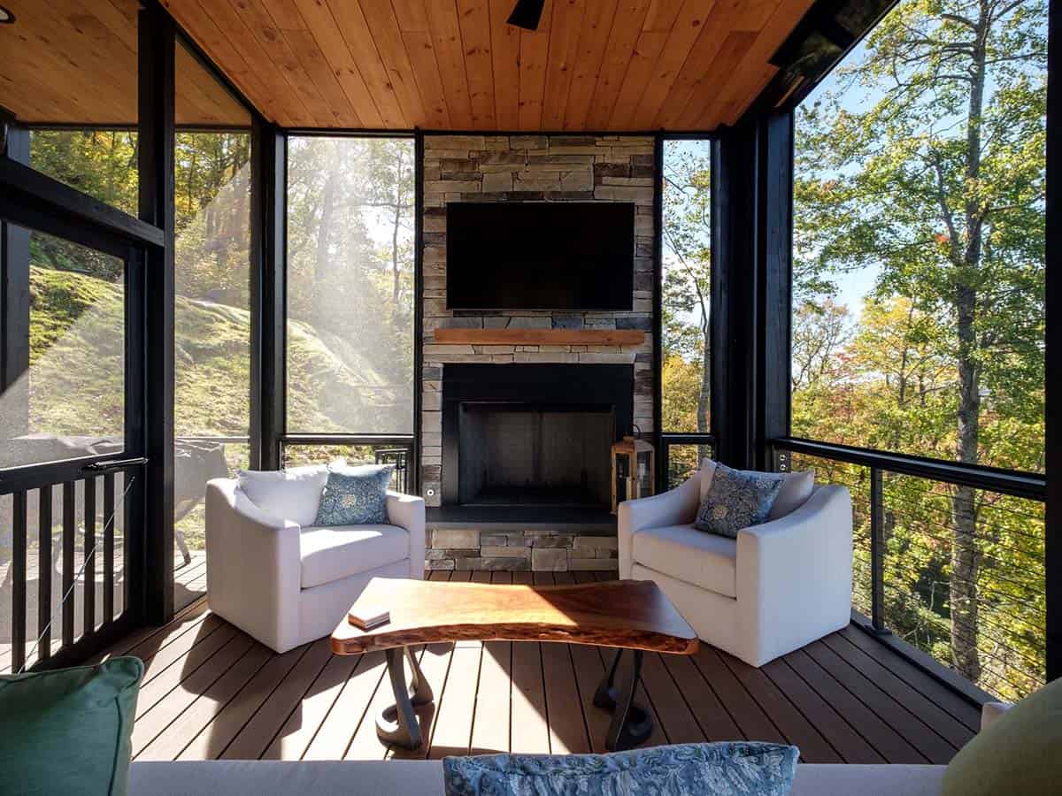 Screened porch with stone fireplace and swivel chairs