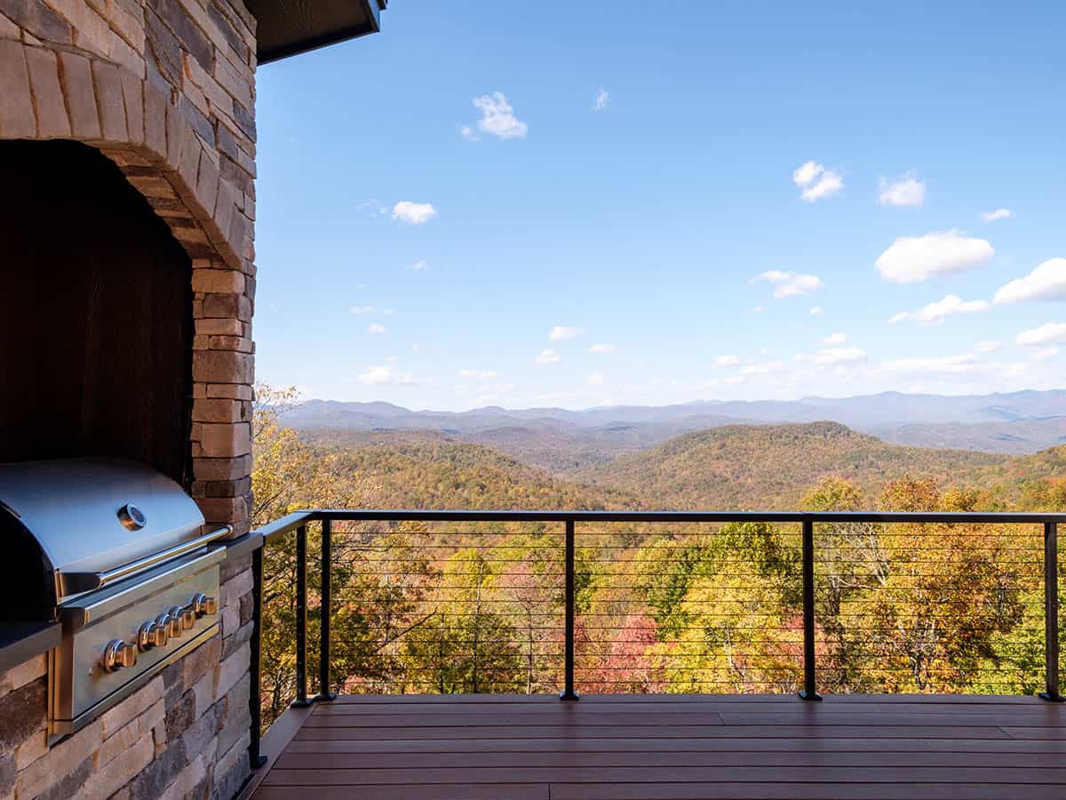 Outdoor kitchen grill built into stone surround with mountain view